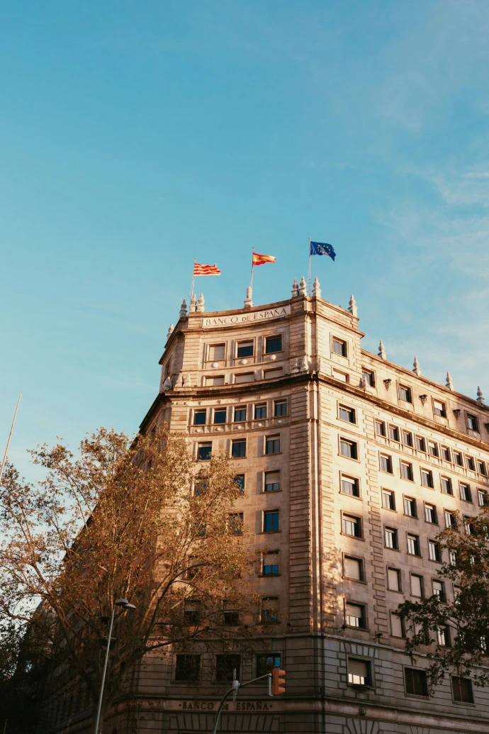 Historic building with flags under a clear blue sky.